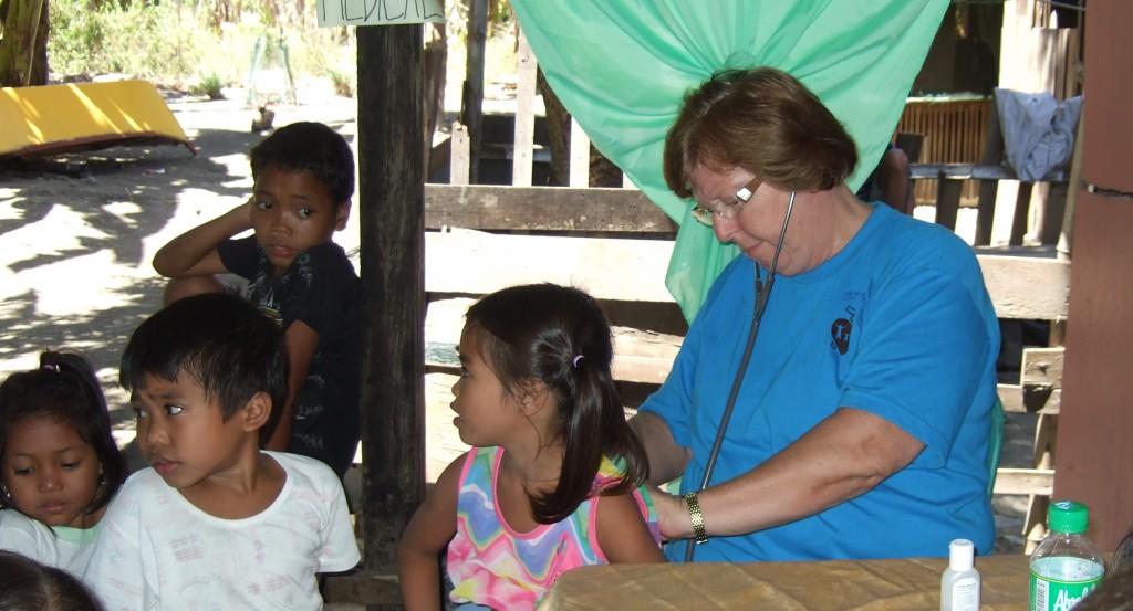 A health worker with a stethoscope examining a child during a checkup